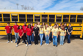  A group of students standing in front of a school bus